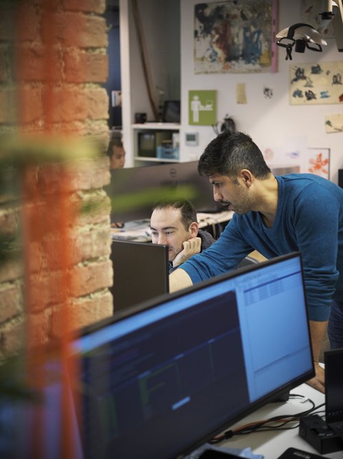 Zwei Personen von IGIT bei der Arbeit vor einem Bildschirm