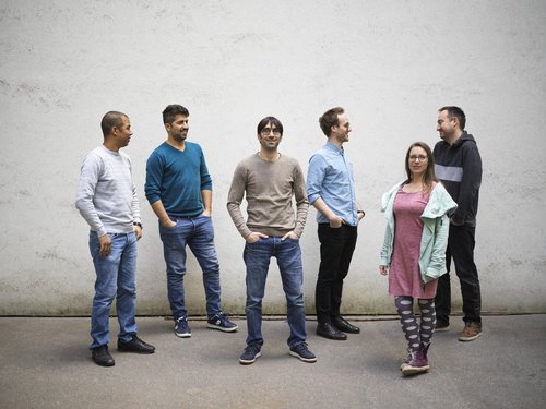 Das IGIT Team steht vor einer grauen Wand.